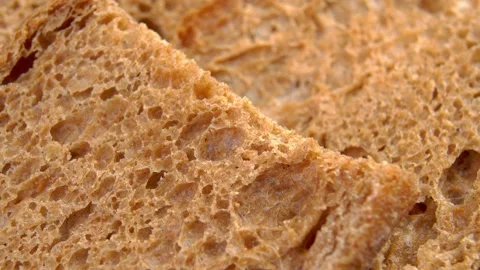 Brown grain bread texture from rye flour. Sliced rustic loaf. Macro Stock Footage 195111475