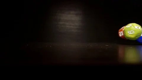 Brown, green and blue polyhedral dice bounce and roll across a table at Stock-Footage 114105609