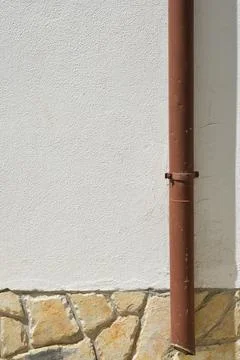 Brown Gutter Downpipe on White Plaster Wall Stock Photos