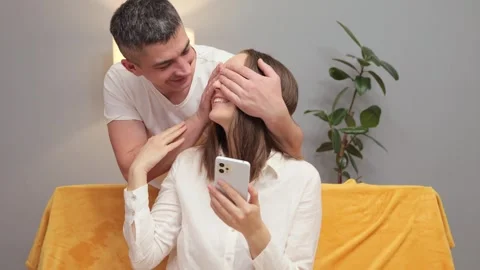 Brown haired woman sitting on the couch and using her mobile phone chatting Vídeo Stock 262532142