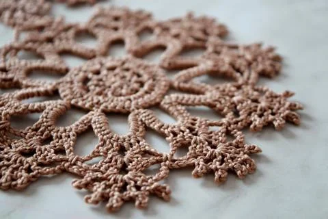 Brown hand hooked coaster. Knitted holders for hot work. Stock Photos