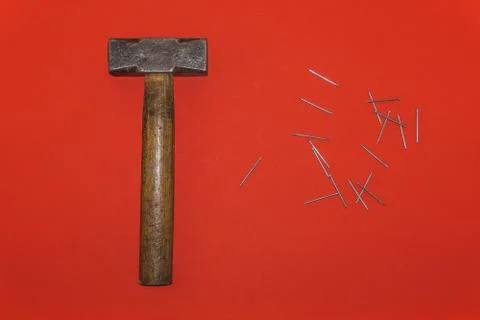 Brown handle hammer with nails on a red background Stock Photos
