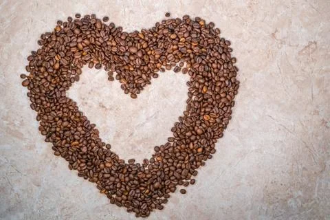 Brown heart-shaped natural roasted coffee beans Stock Photos