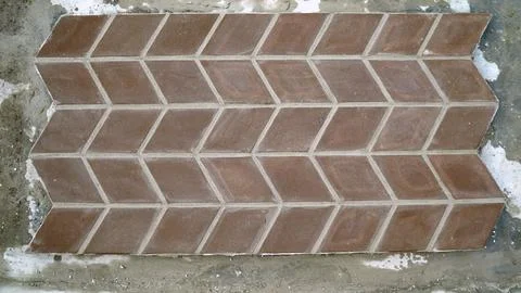 Brown herringbone tile pattern on concrete surface 스톡 사진