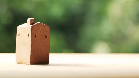 Brown home model made from clay on wooden surface Stock Footage 80903375