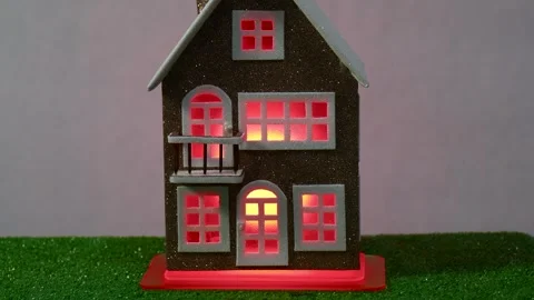 A brown house with a changing glow of light in the windows Stock Footage 265001154