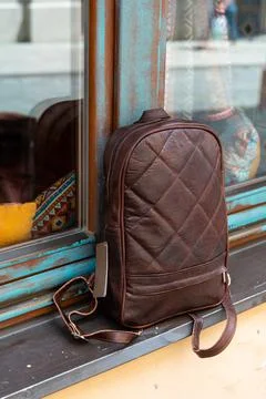 Brown leather backpack on the windowsill Stock Photos