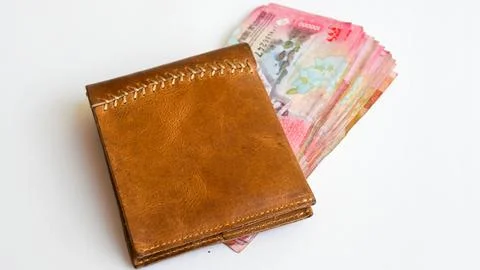 Brown Leather Bifold Wallet with Stack of Indonesian Rupiah on White Background 스톡 사진