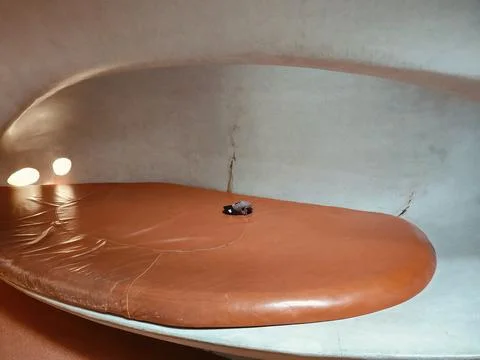 A brown leather couch in the shape of an oval, with small black dots on it .. Stock Photos