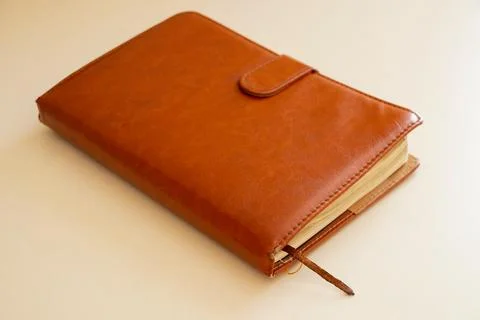 Brown leather notepad lies on a light table in the light Stock Photos