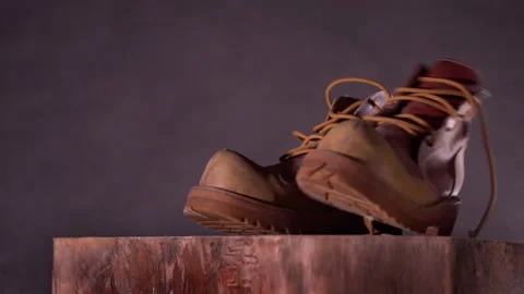 Brown leather shoes slowly fall. Dark gray background. Slow motion Stock Footage 218367746