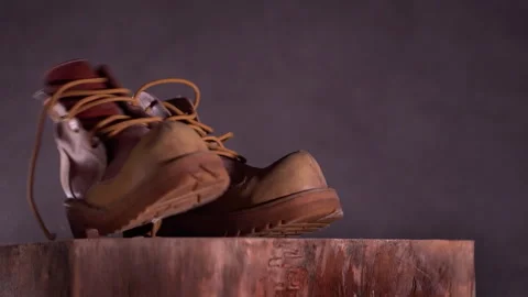 Brown leather shoes slowly fall. Dark gray background. Slow motion Stock Footage 248715280