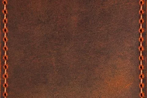 Brown leather surface with stitching along the vertical edges and copyspace.. Stock Photos