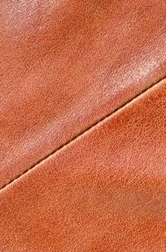 Brown leather texture. Useful as background for any design work. Macro photog Stock Photos