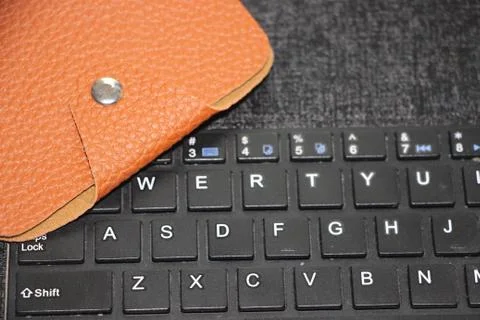 Brown leather wallet put on computer keyboard. Online business web shopping b 库存照片