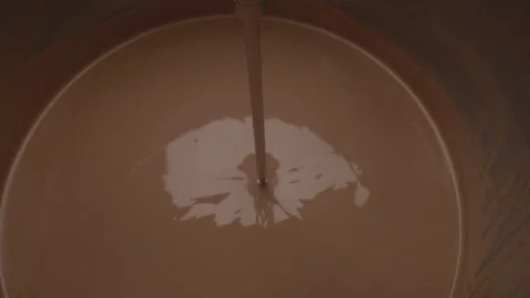 Brown liquid mixture with a rod in a metal container Stock Footage 340282792
