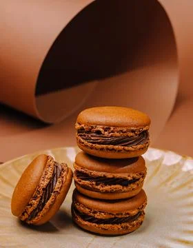 Brown macarons on a plate with a simple background in a kitchen setting 스톡 사진