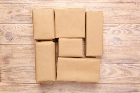 Brown mail package parcel blank for you design. Cardboard box on a wooden bac 库存照片