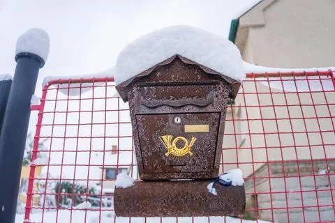 Brown mailbox covered with snow. Old brown iron post box under snow duvet Stock Photos