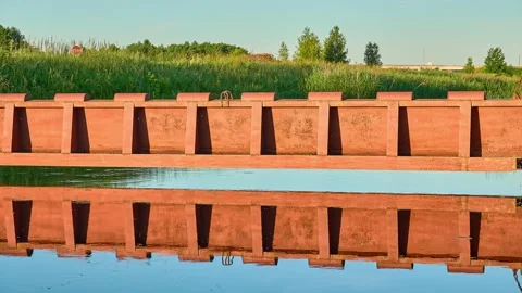 A brown metal dam on a small river. Summer green picturesque nature. Stock Footage 157926077