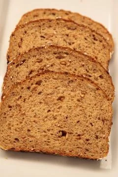 Brown multigrain bread slices on a white plate Foto stock