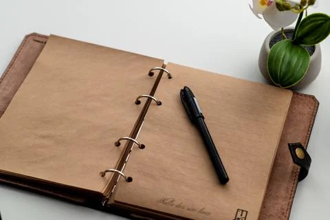 The brown notepad lies on a white table. Stock Photos
