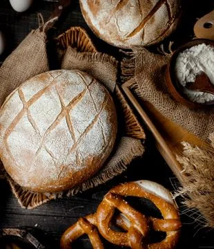 Brown oval bread under white powder on the table Stock Photos