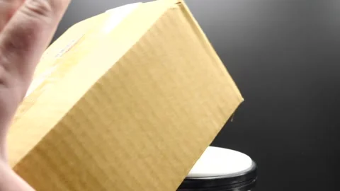 Brown package falling in slow motion isolated on black 스톡 동영상 169777669