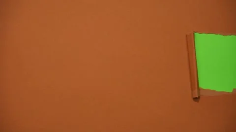 Brown paper background torn in half, revealing a green background. Stop motion Stock-Footage 312409135