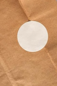 Brown paper bag with circular white label on kraft texture Stock Photos