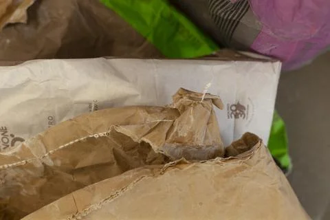 Brown paper bag empty indoor top-down neutral white green plastic bag home. Stock Photos