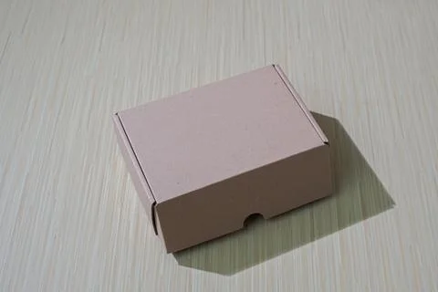 A brown paper box isolated on a table, perfect for packaging or gifting, of.. Stock Photos