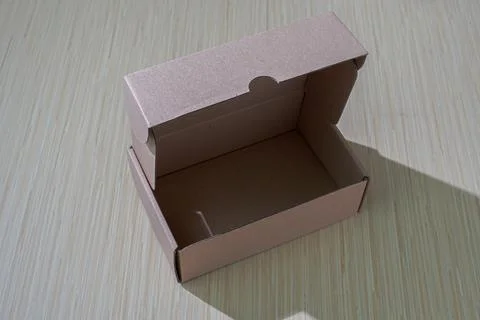 A brown paper box isolated on a table, perfect for packaging or gifting, of.. Stock Photos