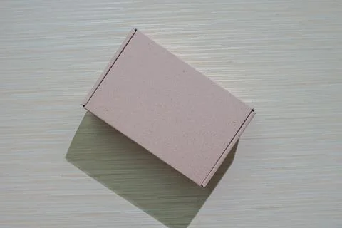 A brown paper box isolated on a table, perfect for packaging or gifting, of.. Stock Photos