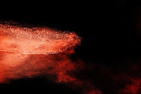 Brown particles exploding on black background, brown dust splashing 写真素材