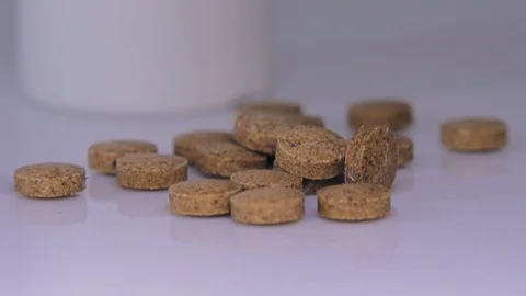 Brown pills with bottle on background. close up, slide up Stock Footage 129607013