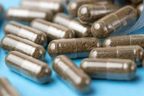 Brown pills, tablets on blue background. Close-up photography of tablets or p Stock Photos