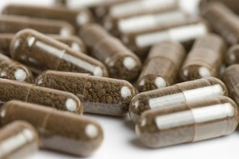 Brown pills, tablets on white background. Close-up photography of tablets or Stock Photos
