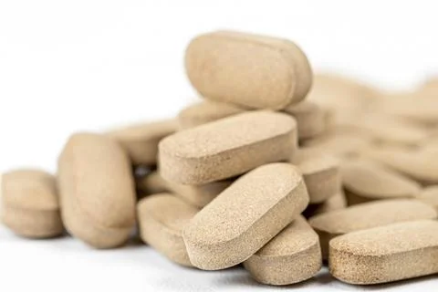 Brown pills on white, close-up Stock Photos