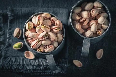 Brown pistachios on dark table. Quick and good snack. Stock Photos