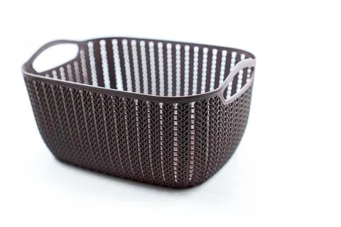 Brown plastic basket with woven pattern on a white Stock Photos
