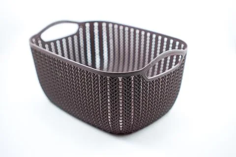 Brown plastic basket with woven pattern on a white Stock Photos