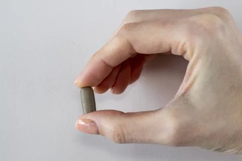 Brown rectangular tablet with rounded corners. This may be a herbal supplement Stock Photos