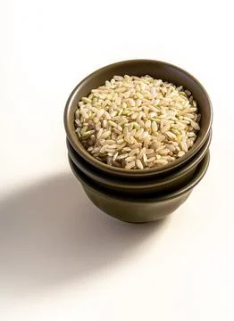 Brown rice in a ceramic bowl stack isolated on white background with clippi.. Stock Photos