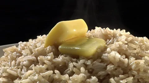 Brown rice with knobs of butter 스톡 동영상 8574004