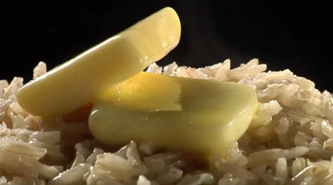 Brown rice with knobs of butter Video stock 8574011