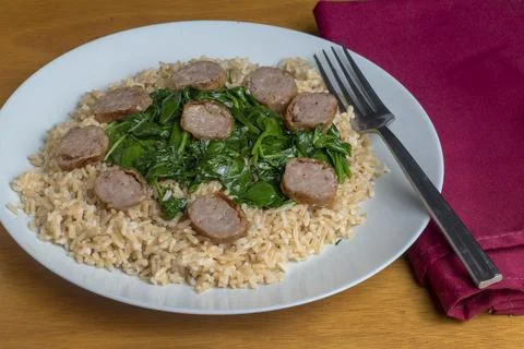 Brown rice top with  sauteed spinach and sausage Foto stock