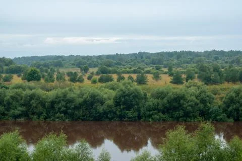 Brown river and dramatic background. The water in the river became dirty after Stock-Fotos