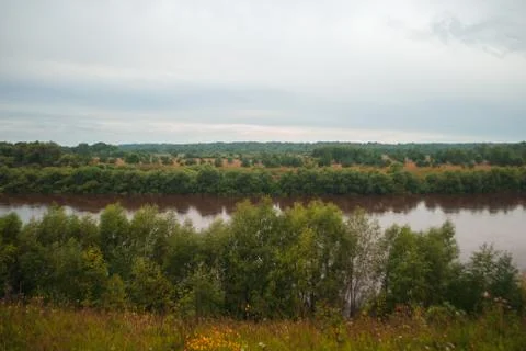 Brown river and dramatic background. The water in the river became dirty after Stock Photos