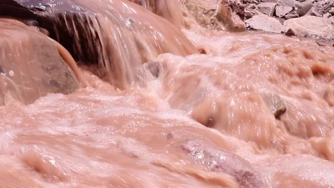 Brown river flowing through rocks Stock Footage 85963793